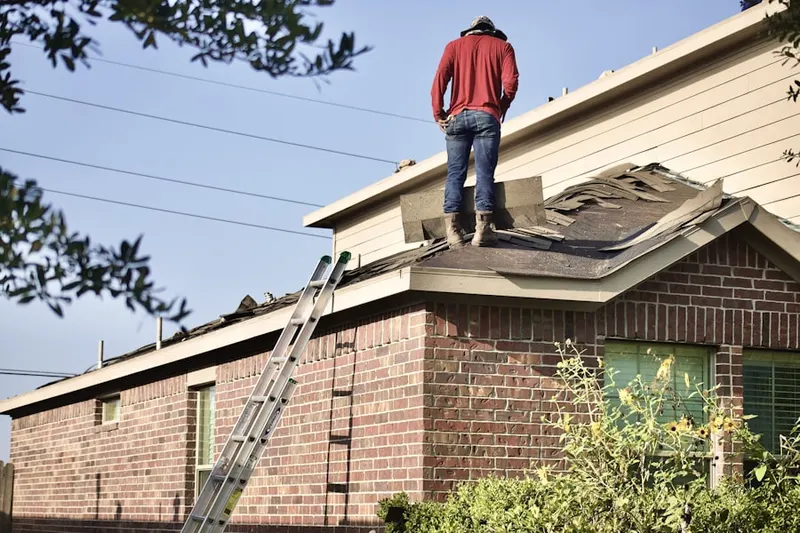Professional roofer working on a residential roof in Elmora